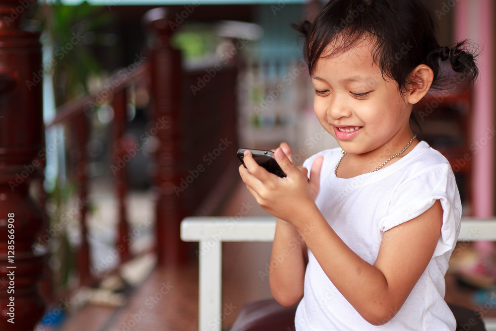 Cute child little girl playing smartphone with happy at home. Cute child little girl playing smartphone with happy at home.