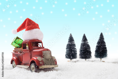 Christmas toy santa truck with gift boxes and pine tree on snow