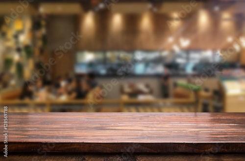 Selected focus empty brown wooden table and Coffee shop blur bac