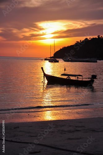 silhouette of a boat floating on a sea during sunset