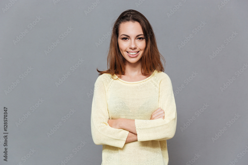 Cheerful smiling woman in sweater standing with arms folded Cheerful smiling woman in sweater standing with arms folded