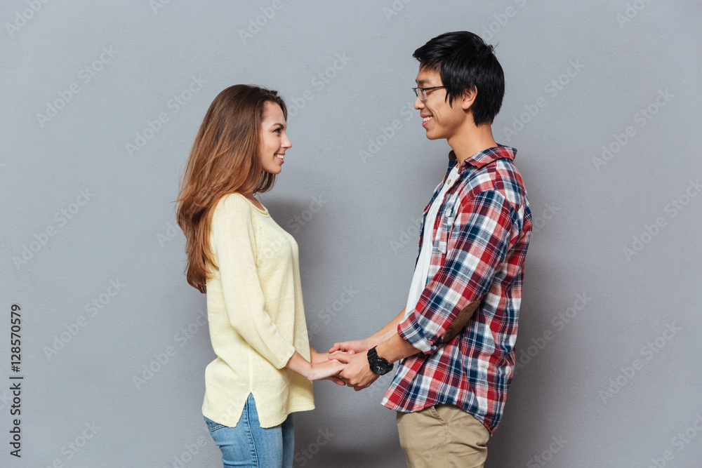 Young happy couple looking at each other and holding hands Young happy couple looking at each other and holding hands