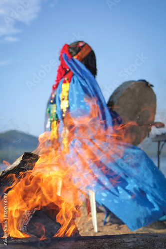 shaman conducts the ceremony near the fire. View through the fire. Authentic photos.