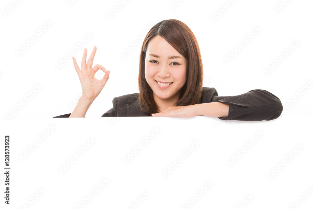 Happy smiling business woman showing ok sign on white board Happy smiling business woman showing ok sign on white board