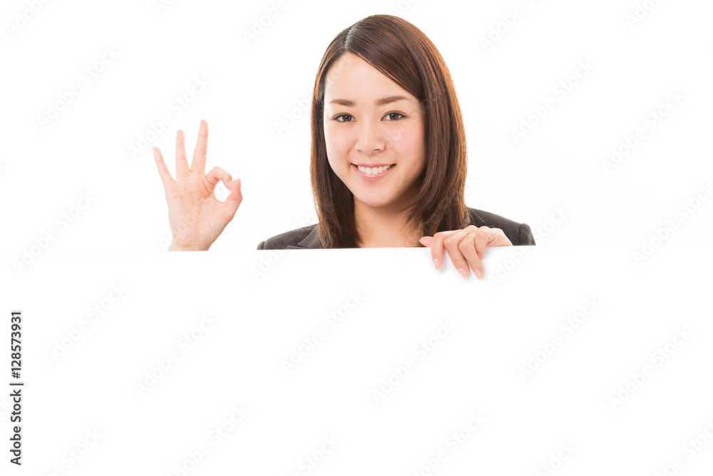 Happy smiling business woman showing ok sign on white board Happy smiling business woman showing ok sign on white board