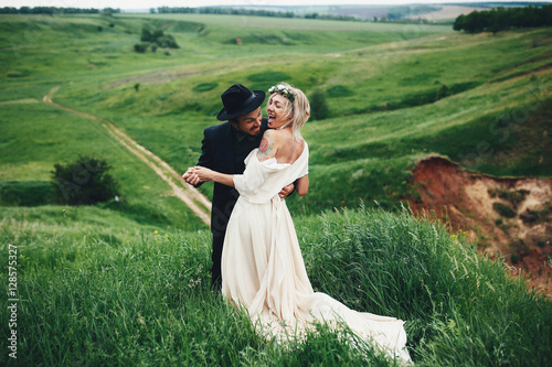 Joyful bride and groom in the lap of the nature