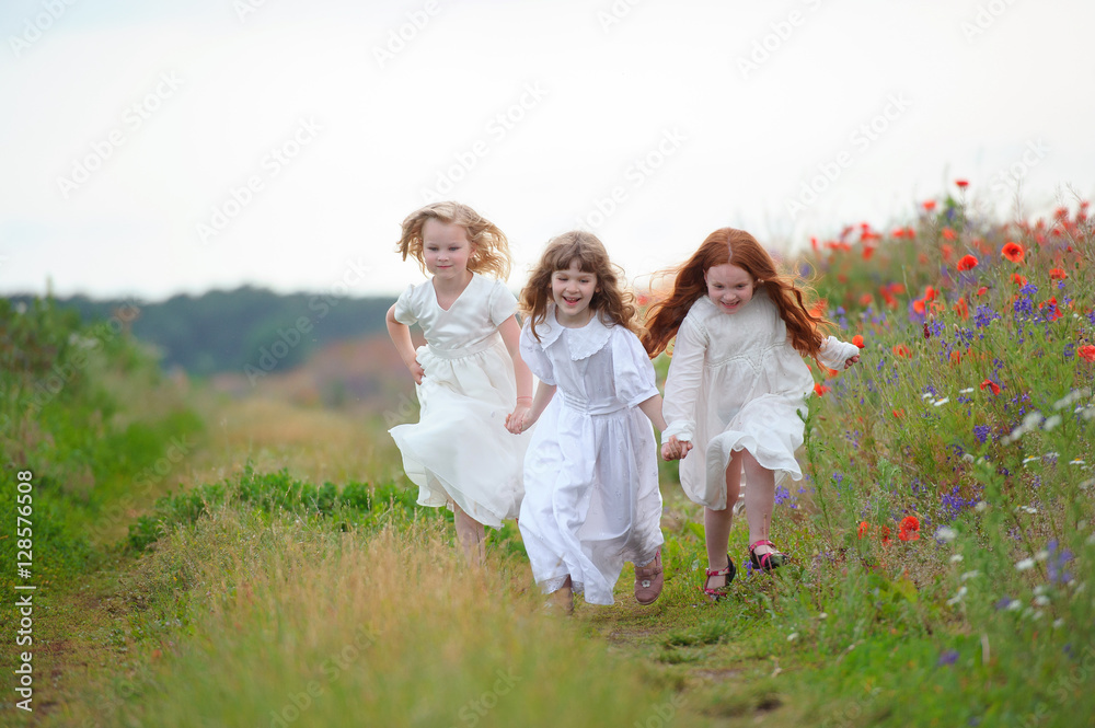 Three happy little girls running on the field Three happy little girls running on the field