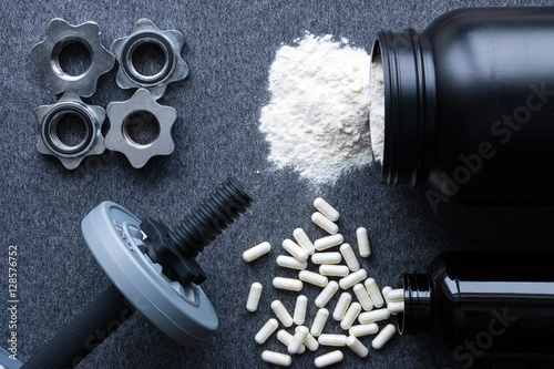 dumbbells, protein and amino acids on a gray background photo