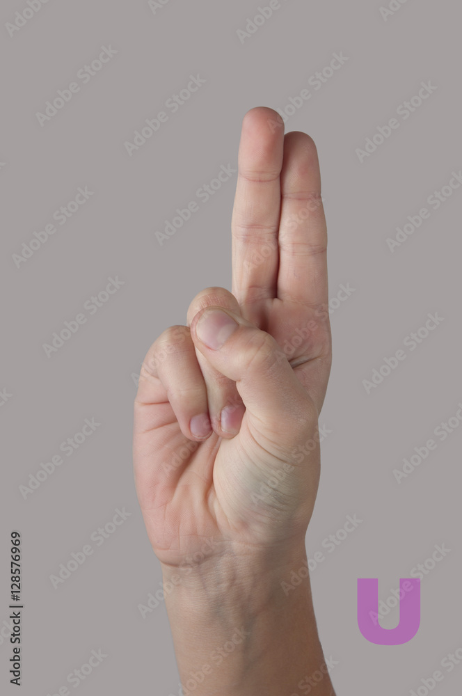 Nonverbal alphabet. Letter U made by fingers on grey background Nonverbal alphabet. Letter U made by fingers on grey background