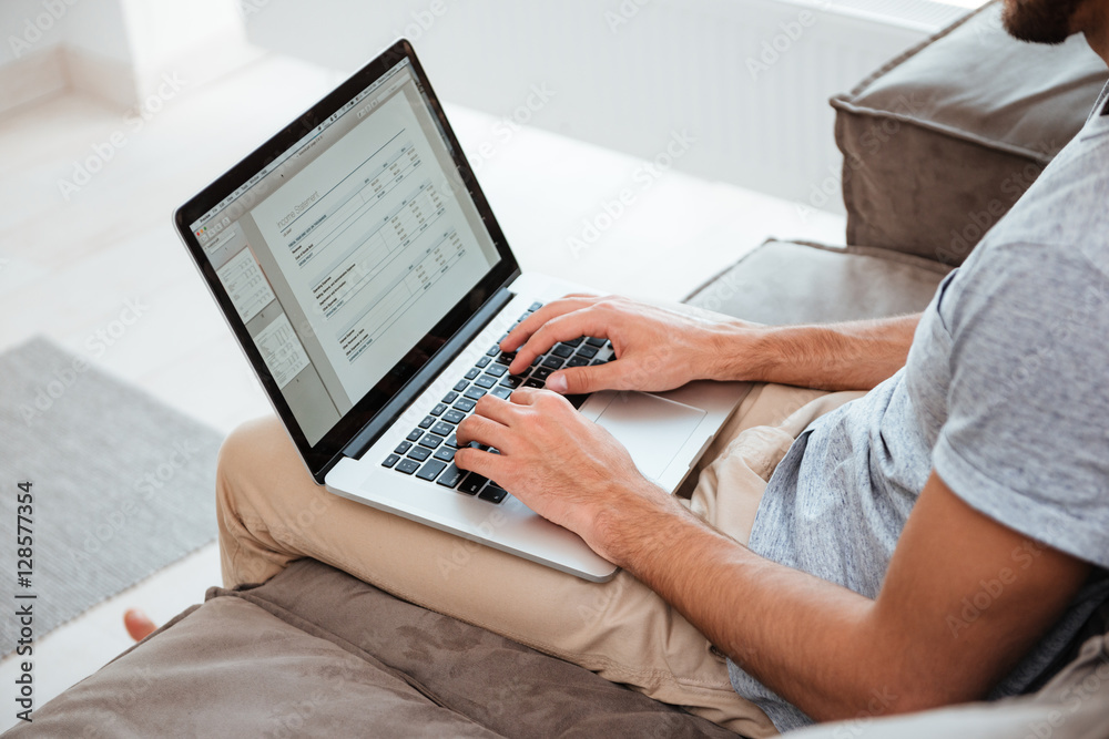 Naklejka premium Cropped image of a young man working on his laptop