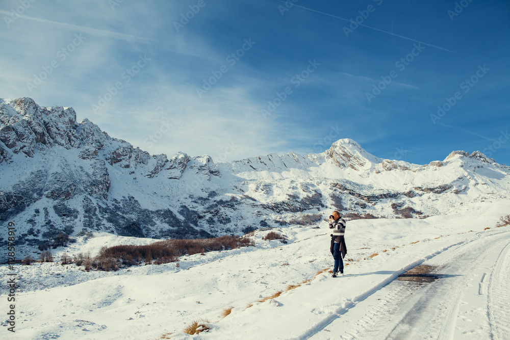 handsome man travel in winter mountains with camera