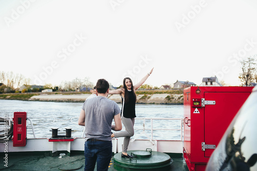 happy and young couple are floating on a yacht photo