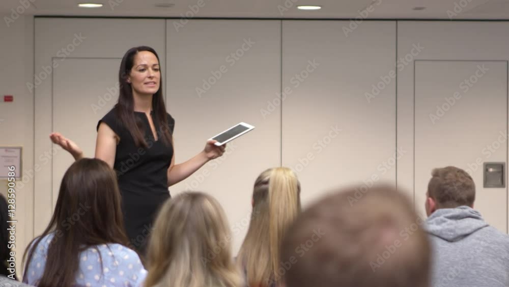 Female teacher addressing university students in class, shot on R3D