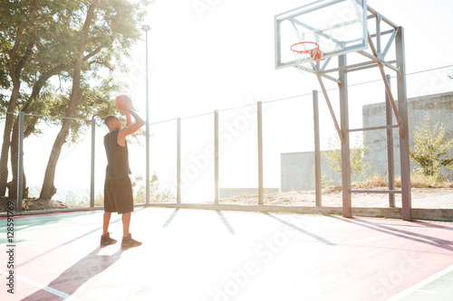 Basketball player practicing in the street with hoop