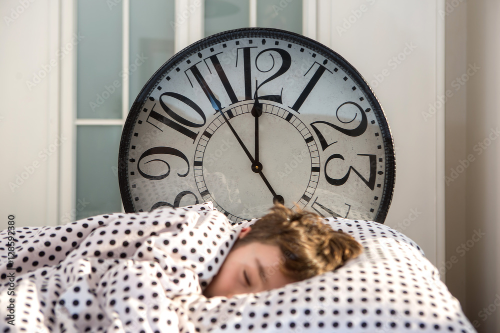 Little boy sleeping with alarm clock