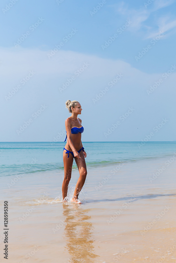 Young slim blonde swimming in sea
