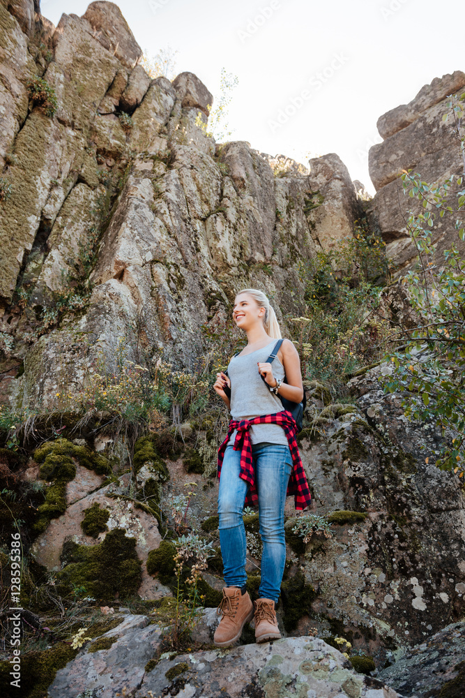Full length traveling girl stands on rock