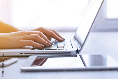 Woman's hands using laptop at the office