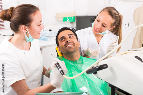 Dentist examines patient at clinic.