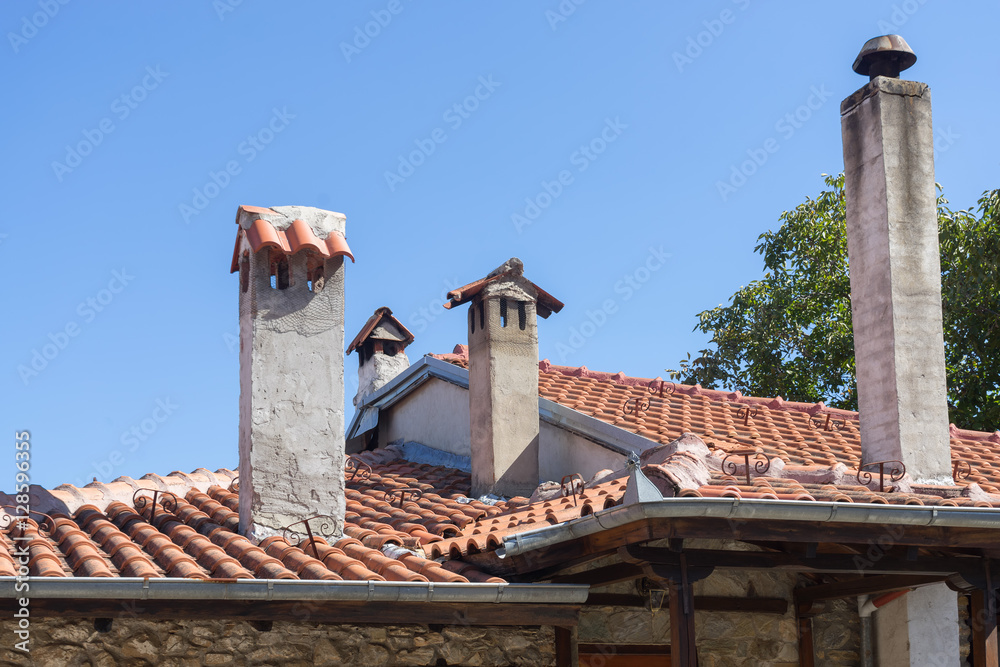 Top view on terracotta schist roof with chimney. Meteora Palaios Panteleimonas, Pieria, Greece.
