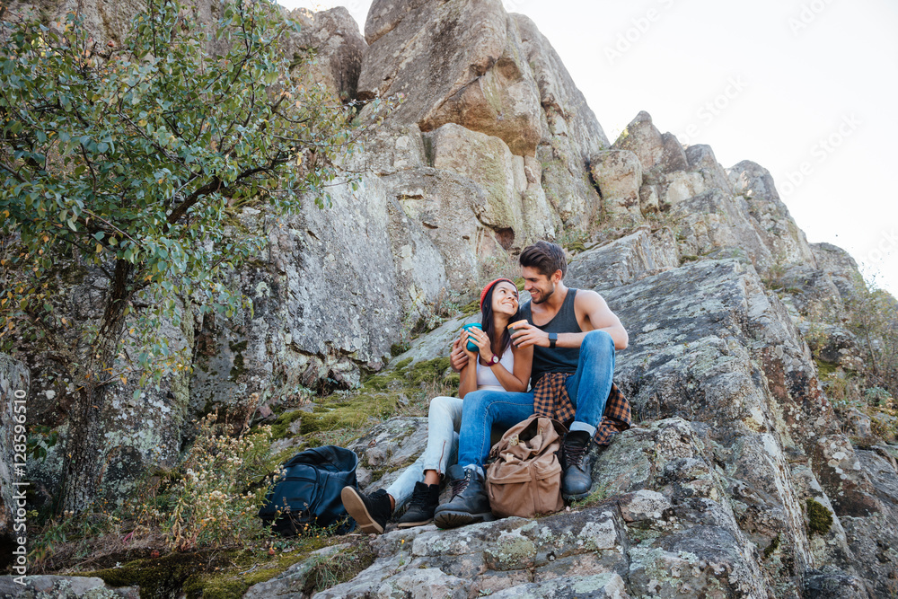 Portrait of a happy couple resting while hiking in mountains