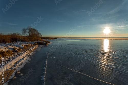 ice with cracks at the coast of the lake on a winter decline