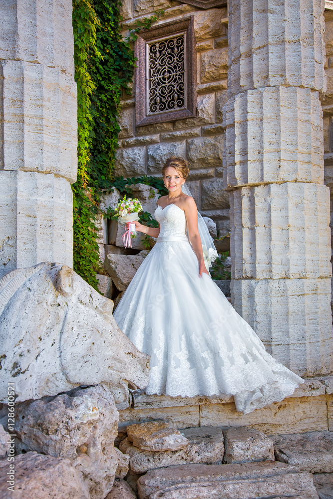 beautiful charming bride standing near the Greek columns