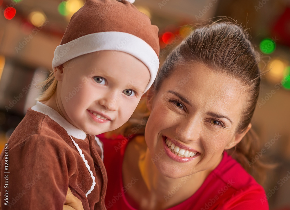 Portrait of smiling mother and baby in christmas decorated kitch Portrait of smiling mother and baby in christmas decorated kitch