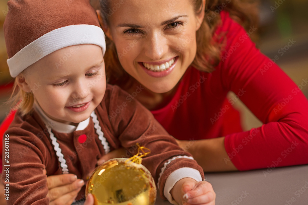 smiling mother and baby holding christmas ball
