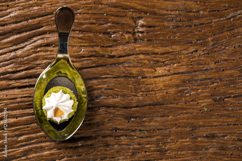 Mini naked cake of lemon juice stuffed with cupuaçu jelly, praline of nuts and Swiss meringue in a spoon. Taste gastronomy fingerfood photo