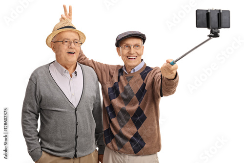 фотографія Elderly man pranking another man with bunny ears and taking self
