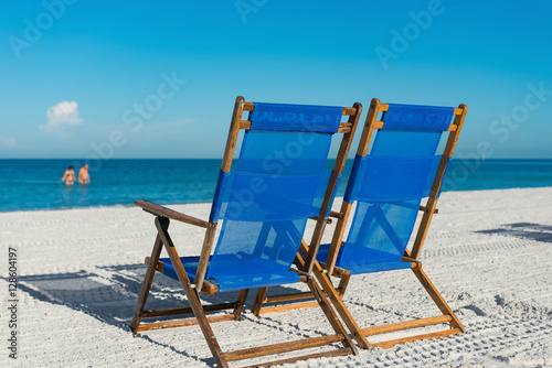 sun loungers on silver sand as  vacation concept
