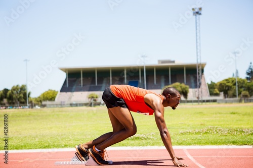 Athlete on a starting block about to run