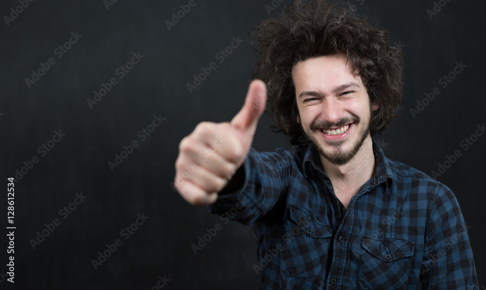 Portrait of a fashionable young man with funny hair on dark back