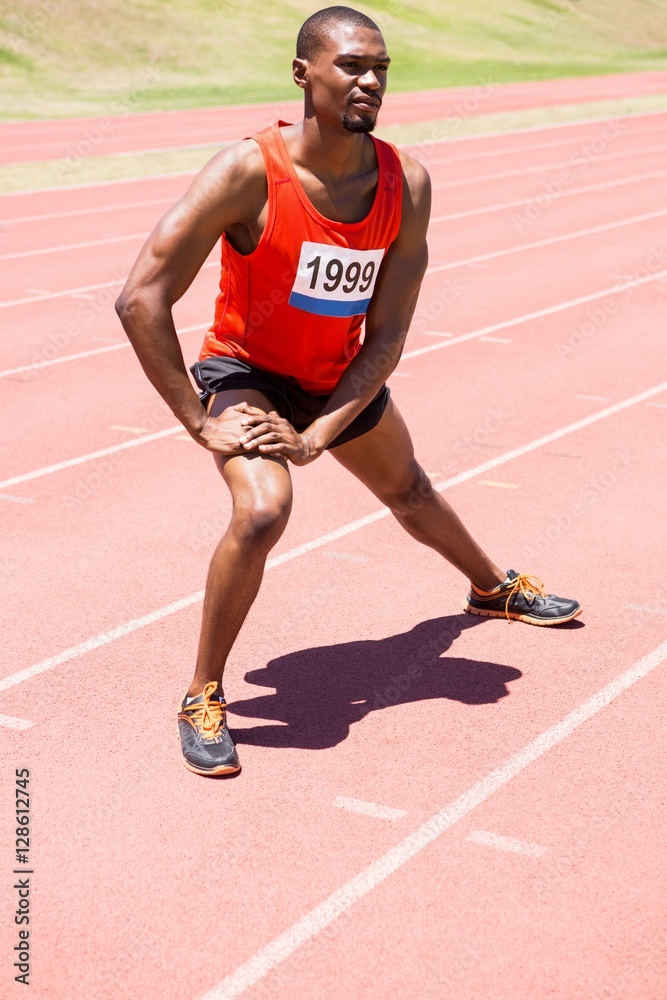 Obraz premium Athlete warming up on the running track