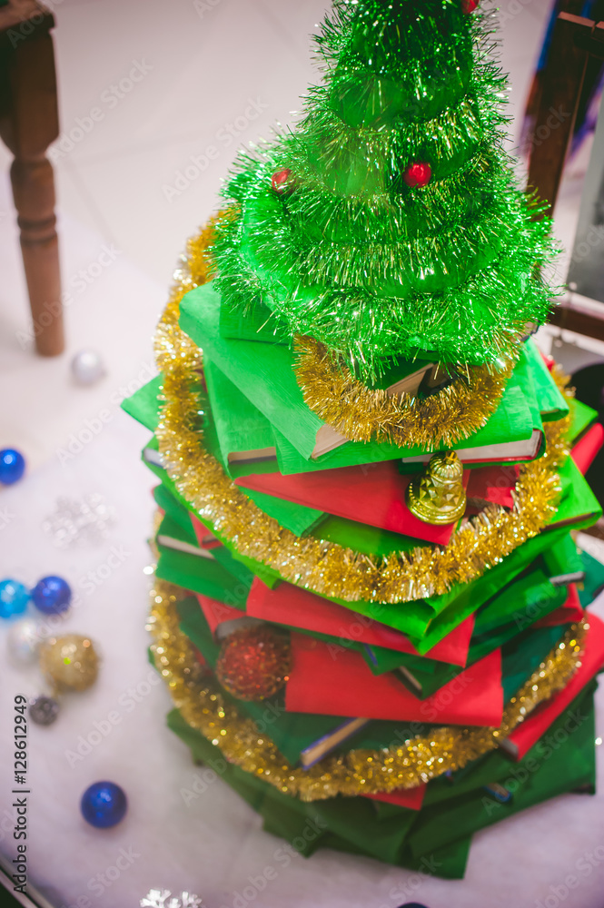 small Christmas tree made of books, decorative toys, gifts for the new year