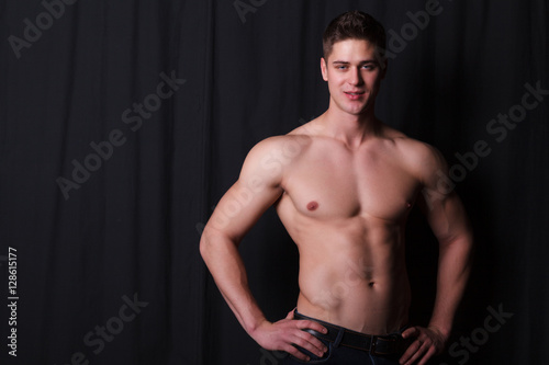 sports guy with a naked torso on a black background © nazarets