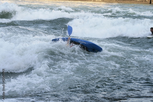 Gekentertes Wildwasserkajak in der Stromschnelle und gefährlichem Rücklauf photo