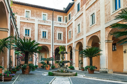 Billede på lærred Cozy italian courtyard with fountain