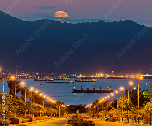 Street to the Red Sea and rising the super moon above Jordanian mountains, Mi...