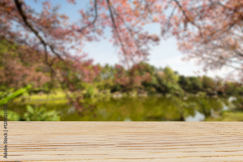 Wooden table top on blurred cherry blossom tree and lake background Wooden table top on blurred cherry blossom tree and lake background