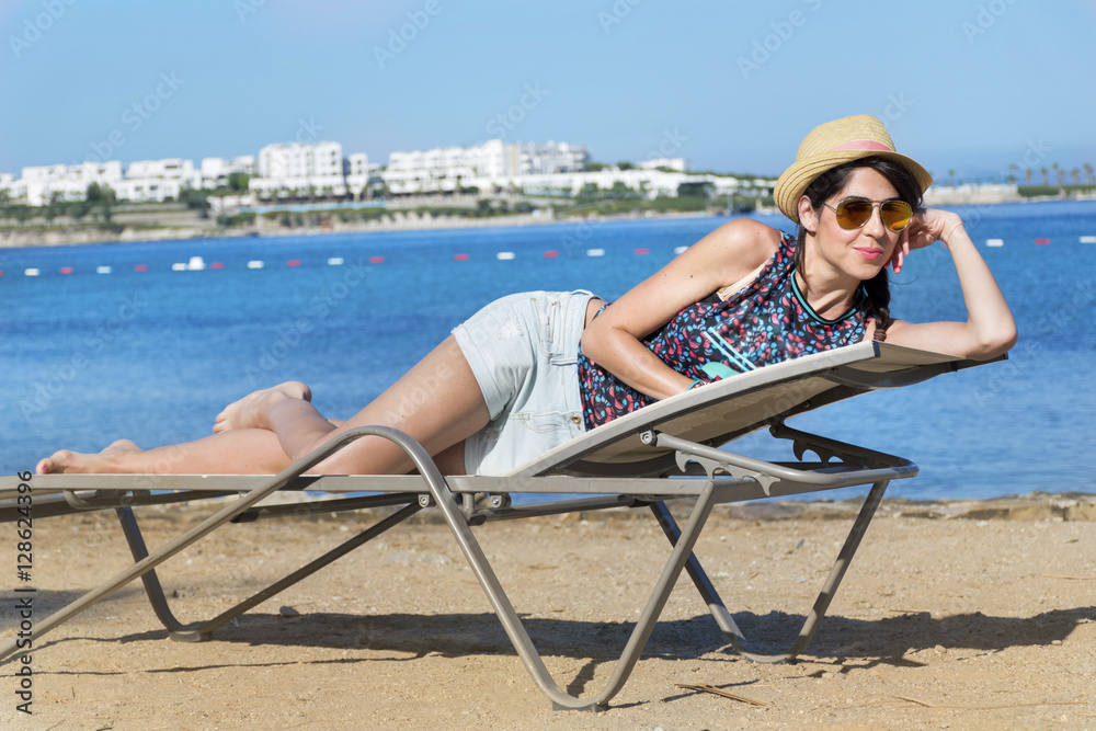beautiful fashion  woman with straw hat relaxing on the beach.Summer holiday concept