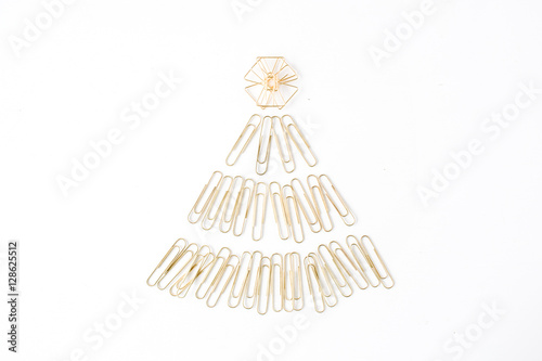 creative arrangement of bright golden christmas tree made of clips on white background. flat lay, top view