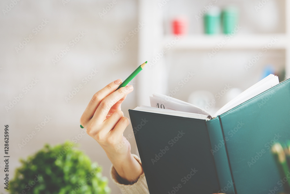 Woman writing in hardcover notepad Woman writing in hardcover notepad