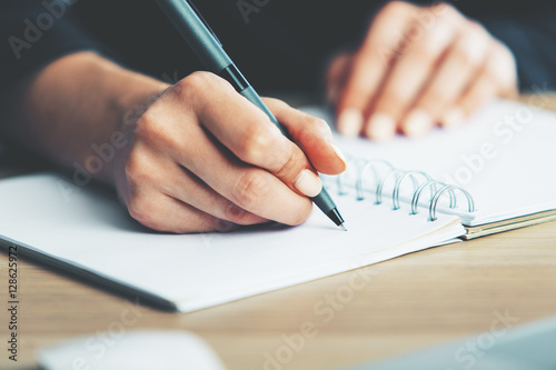 Woman writing in notepad