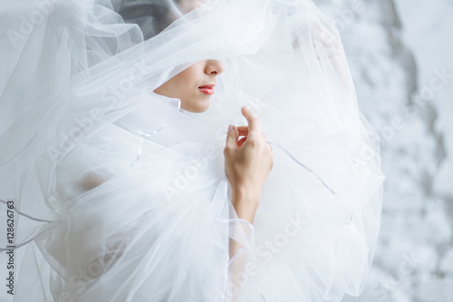 Fotografia red lips of a beautiful woman with white veil on her face