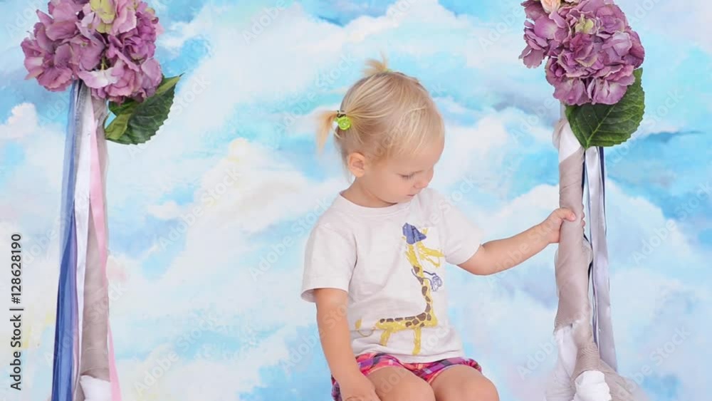 Little girl riding on a swing with flowers Stock Video | Adobe Stock