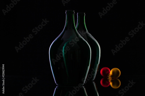 Silhouette of elegant and very old wine bottlesand Christmas decoration on a glass table