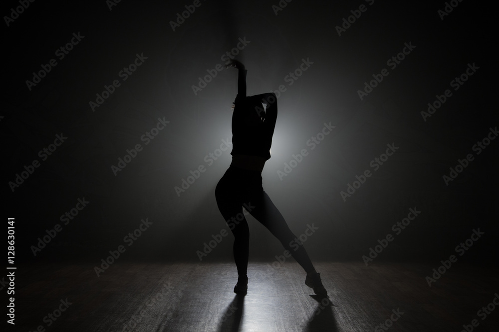 Dancer posing in the dark and smoke