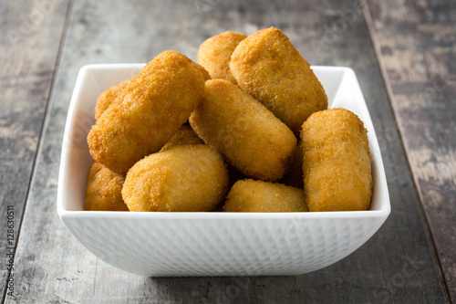 Traditional fried Spanish croquettes on wooden background
